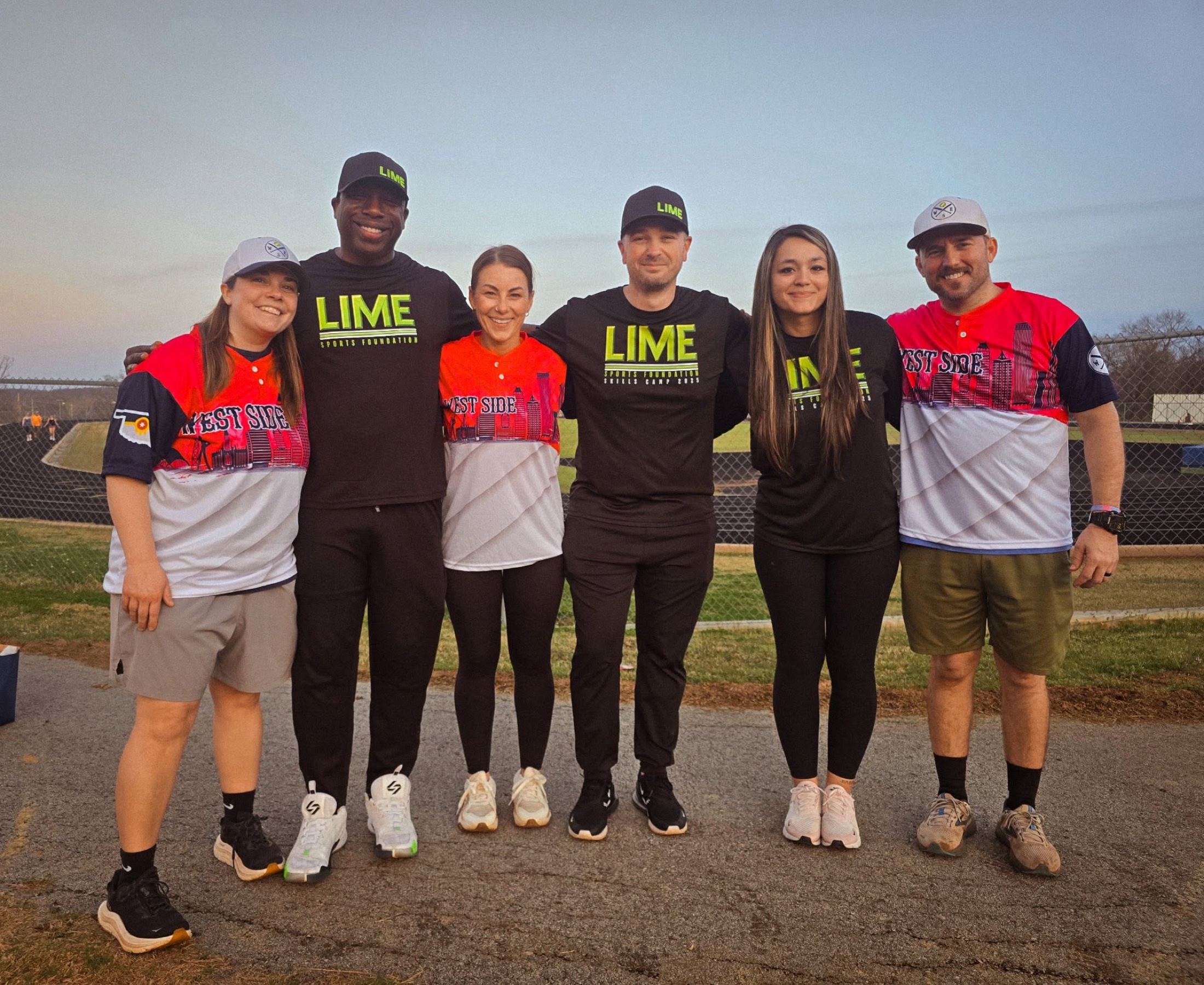 LIME Sports Foundation team members standing with community softball players